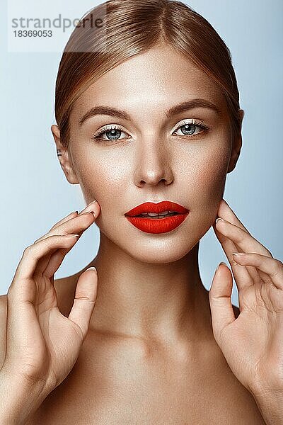 Schönes Mädchen mit roten Lippen und klassischem Make-up. Schönes Gesicht. Foto im Studio aufgenommen
