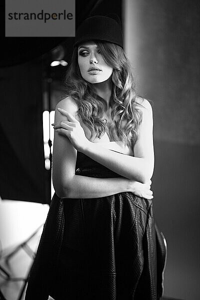 Schönes Mädchen posiert bei einem Fotoshooting im Studio. Schwarz-Weiß-Bild