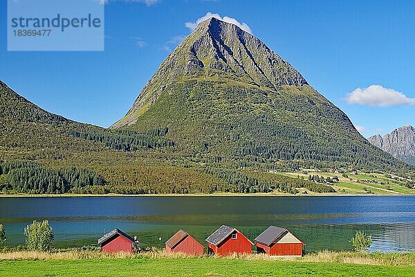 Steile Berge und rote Holzschuppen am Uf eines Fjordes  Aldersund  FV 17  Kystriksveien  Nordland  Norwegen  Europa