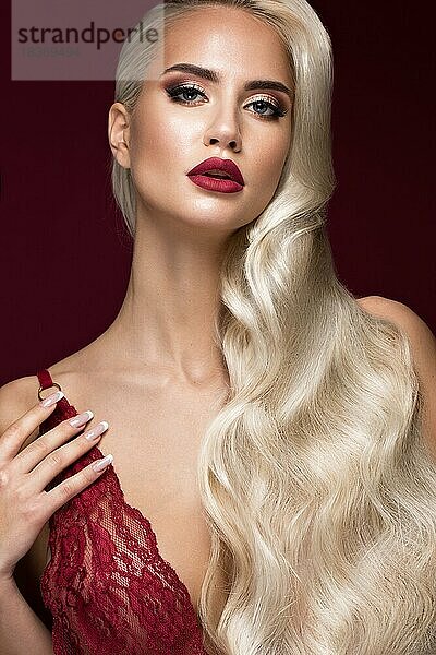 Schöne Blondine in einer Hollywood-Manier mit Locken  roten Lippen  roten Dessous. Schönes Gesicht und Haare. Bild im Studio aufgenommen