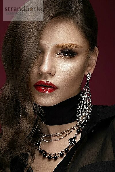 Schönes Mädchen mit roten Lippen und goldenen Augenbrauen  Locken im Hollywood-Stil. Schönes Gesicht. Foto im Studio aufgenommen