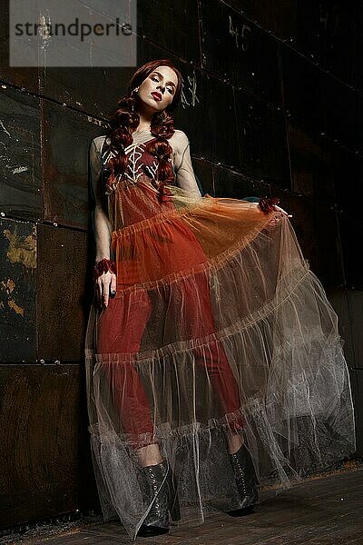 Schönes Mädchen in Designer modische transparente Kleidung posiert im Studio. Schönheit von Gesicht und Körper