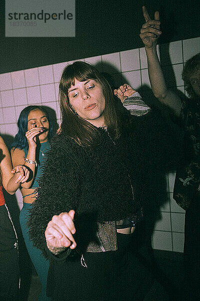 Transgender-Frau tanzt im Nachtclub gegen Freunde