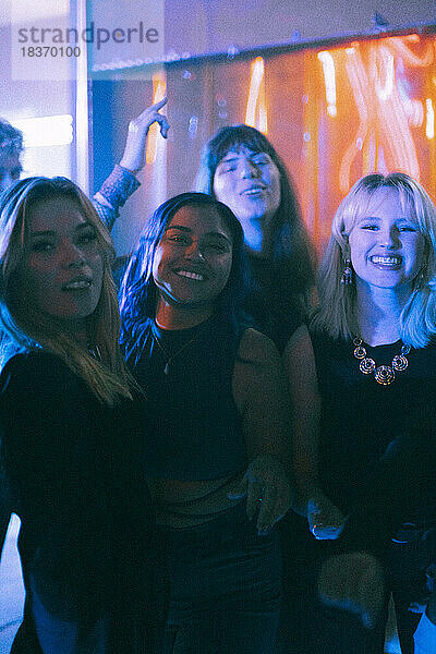 Porträt von glücklichen jungen gemischtrassigen Frauen  die sich gemeinsam in einem Nachtclub vergnügen