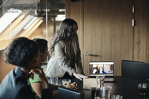 Unternehmerin bei Videogespräch über Laptop mit Geschäftsfrauen im Büro