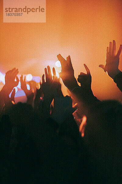 Silhouette erhobenen Händen von Männern und Frauen tanzen in einem Nachtclub