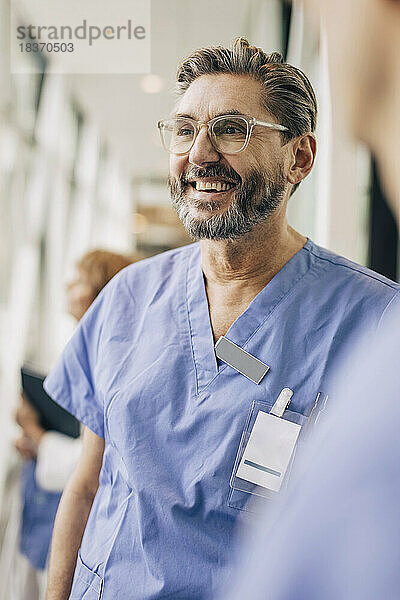 Glücklicher reifer männlicher Arzt in Kitteln im Krankenhaus