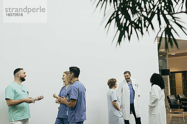 Ein Team aus männlichen und weiblichen Mitarbeitern des Gesundheitswesens bespricht sich im Krankenhaus