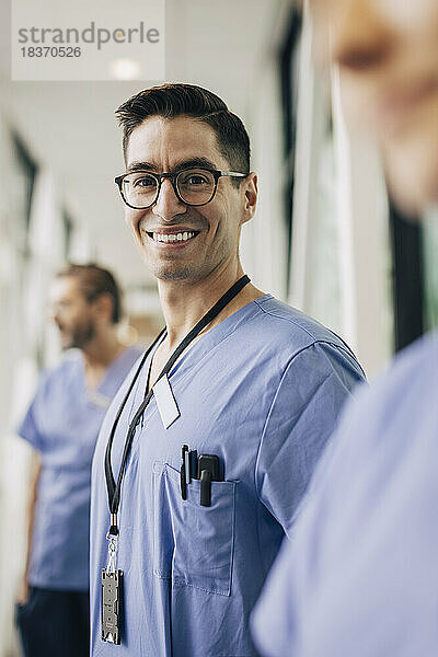 Porträt eines glücklichen männlichen Pflegepersonals mit Brille im Krankenhaus