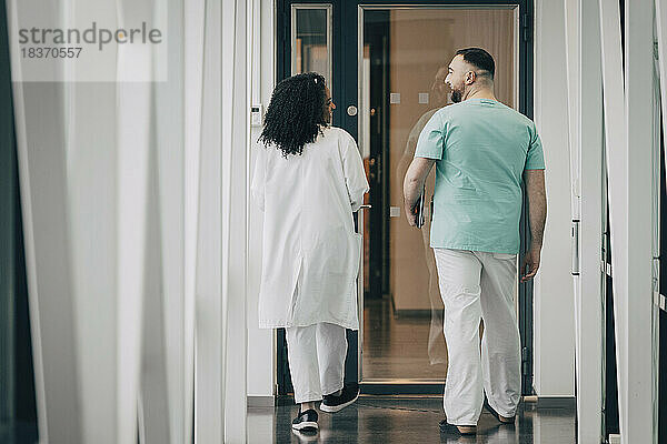 Rückansicht von männlichem und weiblichem Krankenhauspersonal  die zur Tür gehen