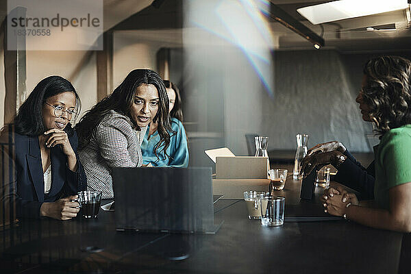 Geschäftsfrauen  die eine Besprechung am Laptop am Schreibtisch im Büro abhalten