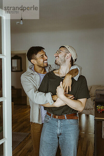 Glückliches homosexuelles Paar  das sich im Schlafzimmer zu Hause gegenseitig anschaut