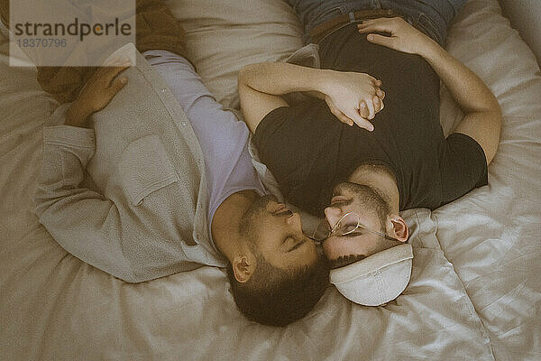 Hohe Winkel Ansicht der Homosexuell Paar auf dem Bett liegend mit geschlossenen Augen ruhen zu Hause