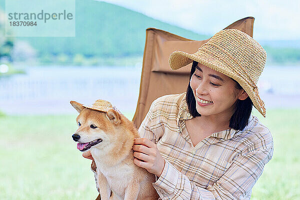 Junge Japanerin mit Hund auf dem Campingplatz