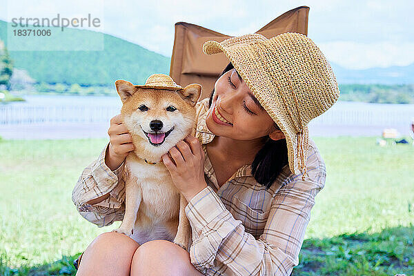 Junge Japanerin mit Hund auf dem Campingplatz