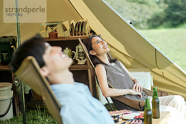 Junges japanisches Paar auf dem Campingplatz