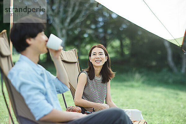 Junges japanisches Paar auf dem Campingplatz