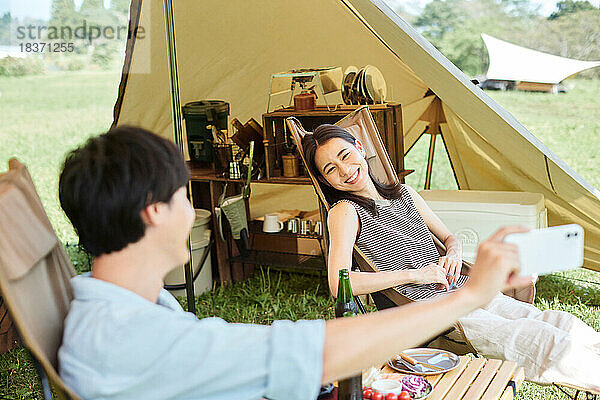 Junges japanisches Paar auf dem Campingplatz