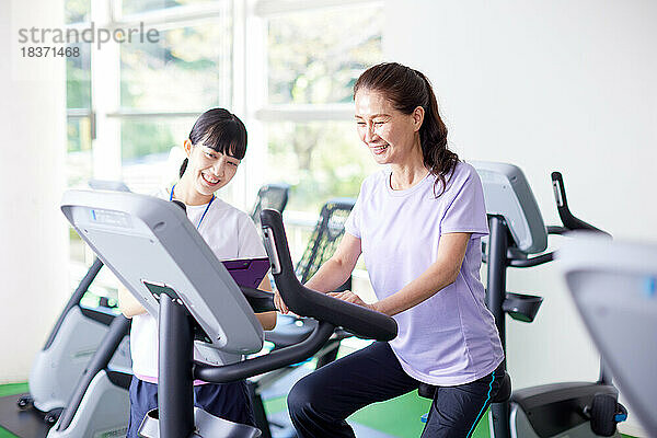 Japanische Seniorin trainiert im Indoor-Fitnessstudio