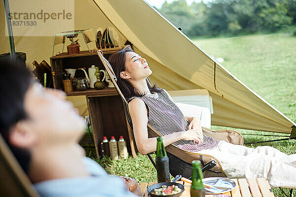 Junges japanisches Paar auf dem Campingplatz