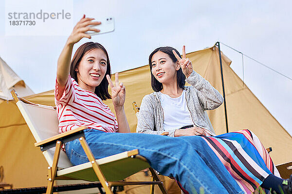 Junge japanische Frauen auf dem Campingplatz