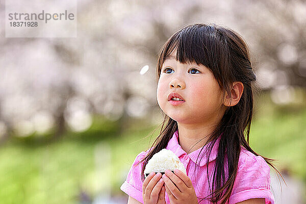 Japanisches Kinderporträt mit blühenden Kirschblüten