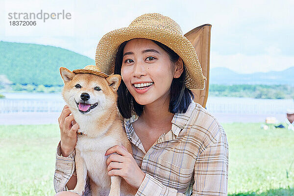 Junge Japanerin mit Hund auf dem Campingplatz