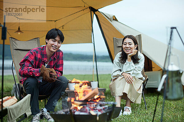 Junges japanisches Paar auf dem Campingplatz