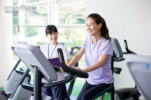 Japanische Seniorin trainiert im Indoor-Fitnessstudio