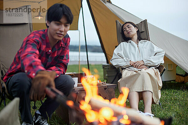 Junges japanisches Paar auf dem Campingplatz