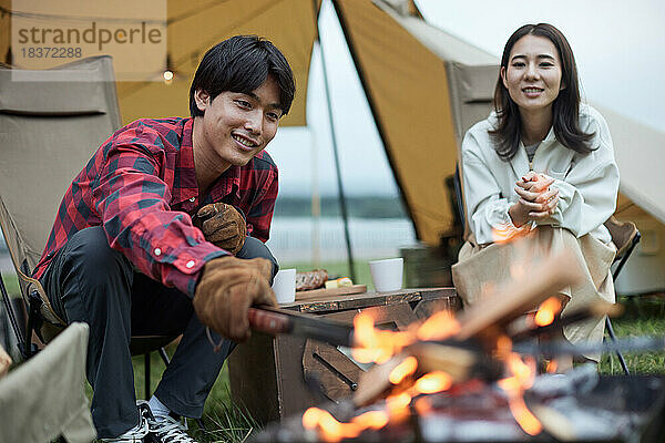 Junges japanisches Paar auf dem Campingplatz