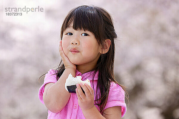 Japanisches Kinderporträt mit blühenden Kirschblüten