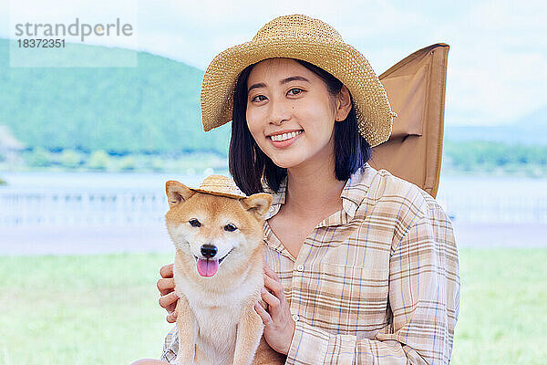 Junge Japanerin mit Hund auf dem Campingplatz