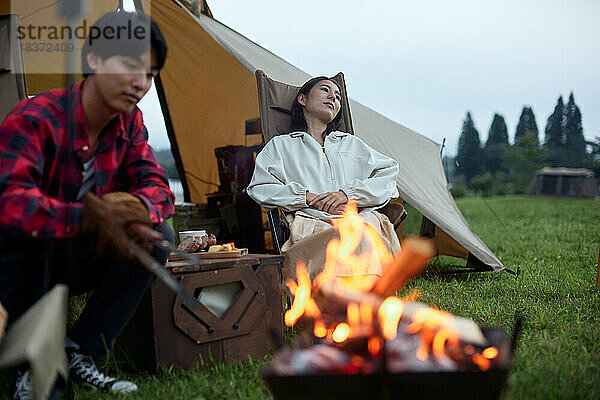 Junges japanisches Paar auf dem Campingplatz