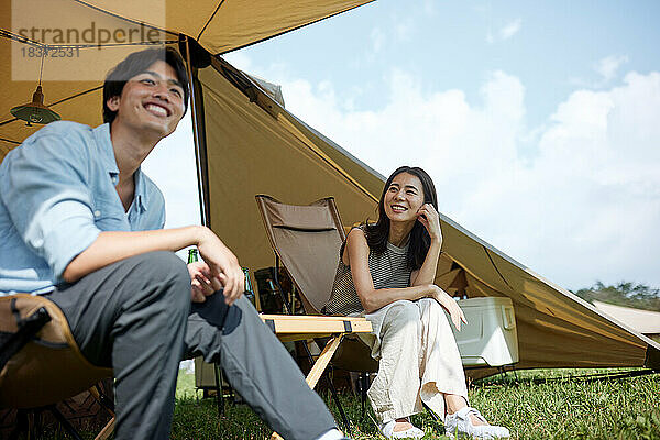 Junges japanisches Paar auf dem Campingplatz