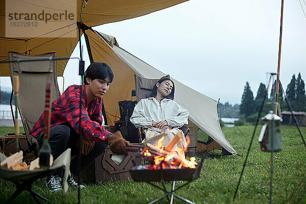 Junges japanisches Paar auf dem Campingplatz