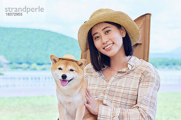 Junge Japanerin mit Hund auf dem Campingplatz