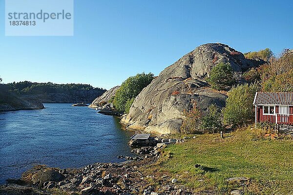 Gerundete Granitfelsen  seichte Buchten und kleine Hütte am Ufer eines Fjordes  Schärenküste  Bohulän  Schweden  Europa