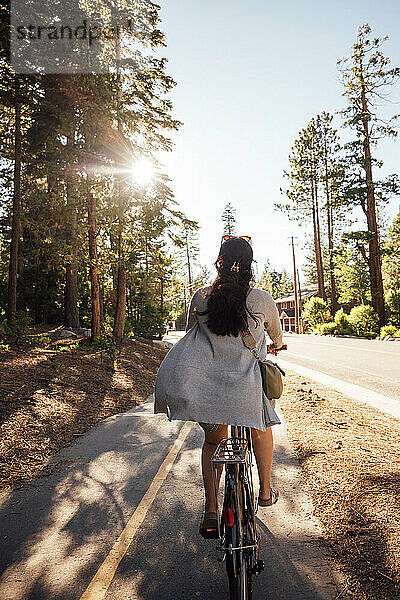 USA  Kalifornien  Tahoe City  Rückansicht einer Frau  die auf dem Radweg Fahrrad fährt