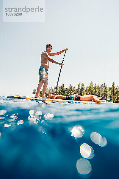 USA  Kalifornien  Vater und Sohn (10-11) paddeln auf dem ruhigen Lake Tahoe