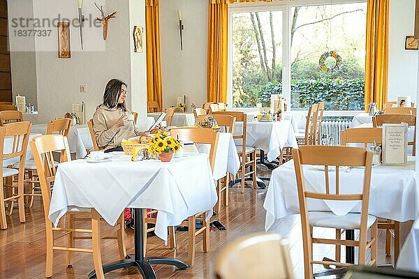 Attraktive Wanders Frau sitzt an Frühstückstisch in einem Hotel  Bad Wildbad  Schwarzwald  Deutschland  Europa