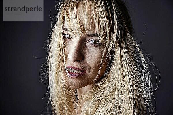 Gesicht einer verführerischen jungen Frau mit langem  blonden Haar  closeup  Portrait  Studioaufnahme