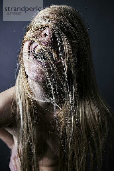 Junge  nackte Frau verdeckt lachend ihr Gesicht mit ihrem wilden  langen  blonden Haar  Studioaufnahme  Köln  Nordrhein-Westfalen  Deutschland  Europa