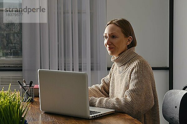 Eine Frau mittleren Alters  die ihre Arbeit liebt  arbeitet bis spät in die Nacht im Büro