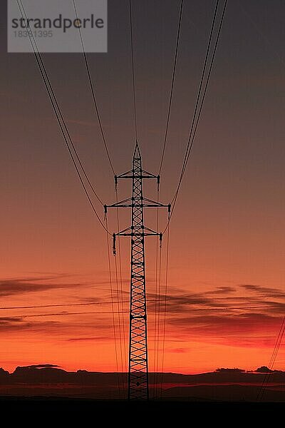 Silhouette von Hochspannungsleitungen und Sendemasten durch das Mährische Feld bei Sonnenaufgang