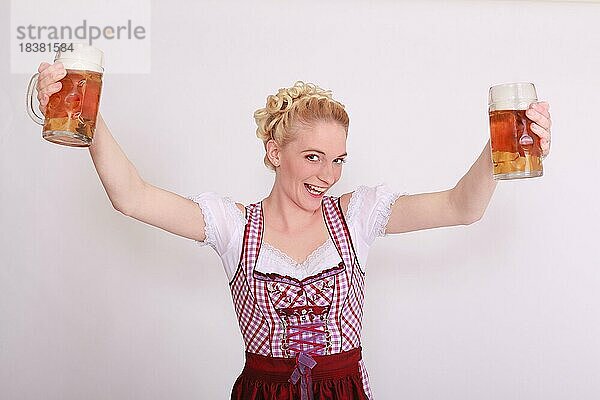 Blonde Frau im Dirndl mit zwei vollen Bierkrügen