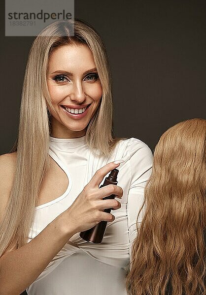 Schönes blondes Mädchen mit einem perfekt Haar  und klassisches Makeup mit einer Haarsträhne für die Verlängerung. Schönheit Gesicht und Haar. Bild im Studio aufgenommen