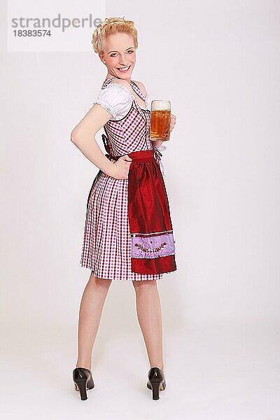 Blonde Frau im Dirndl mit einem Masskrug