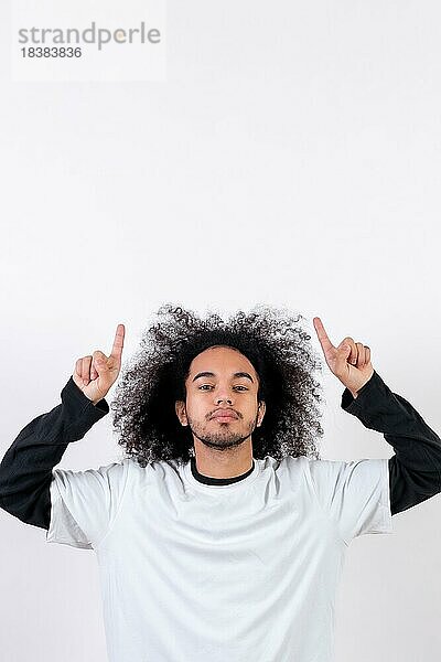 Zeigt über einen Copy Paste Raum. Junger Mann mit Afro Haar auf weißem Hintergrund