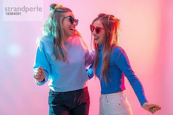 Zwei junge blonde kaukasische Frauen tanzen in einem Nachtclub und haben eine Menge Spaß beim Tanzen